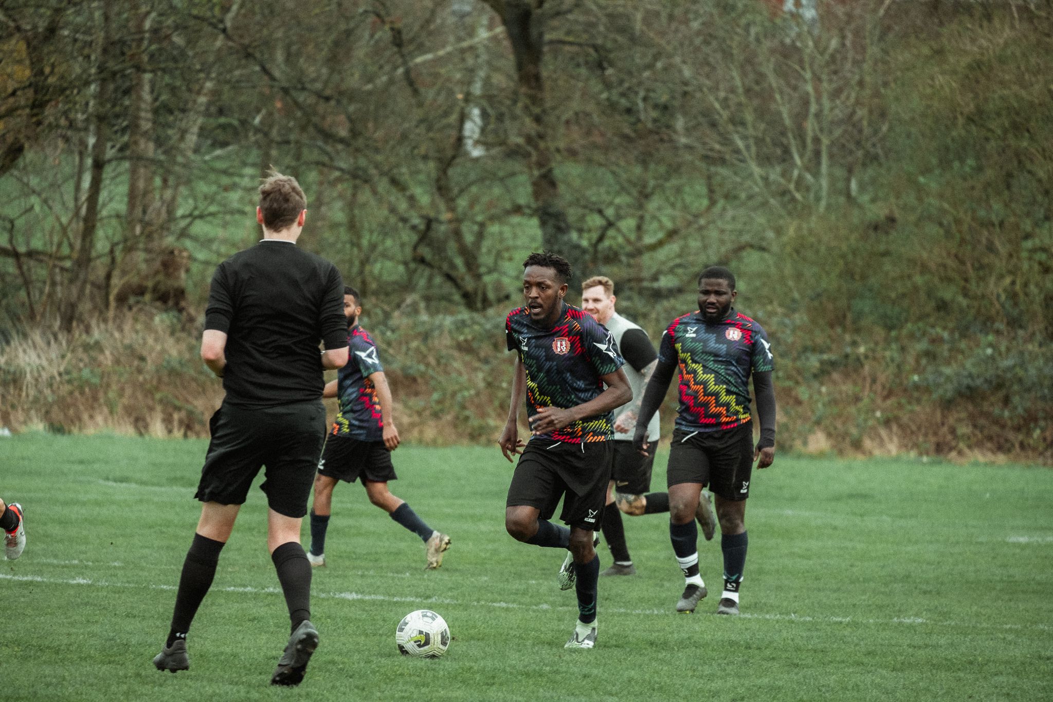 Changing Lives FC Refugee Football Player dribbling in the Klabu Teamwear Multisport Shirt