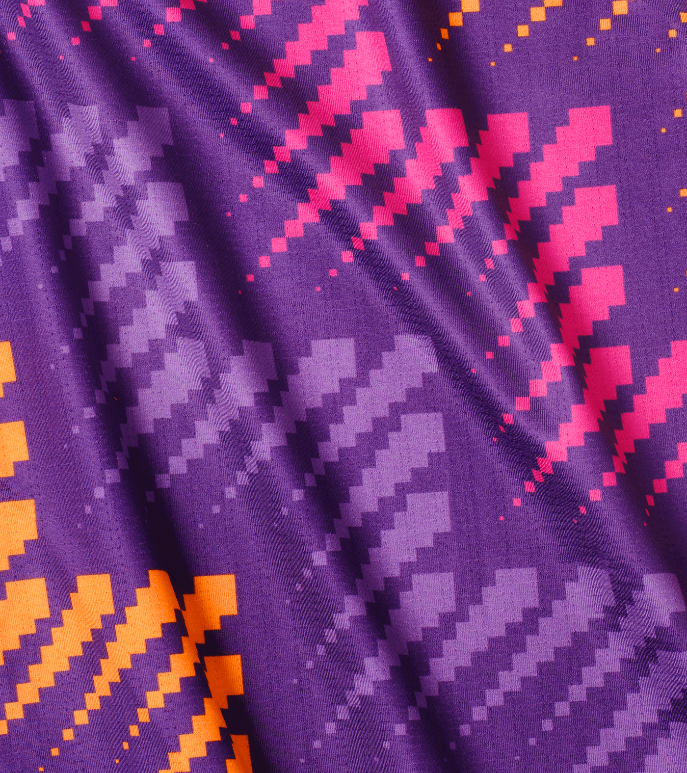 Purple fabric with a pixelated pattern of pink and orange zigzag stripes, creating a vibrant, dynamic geometric design.