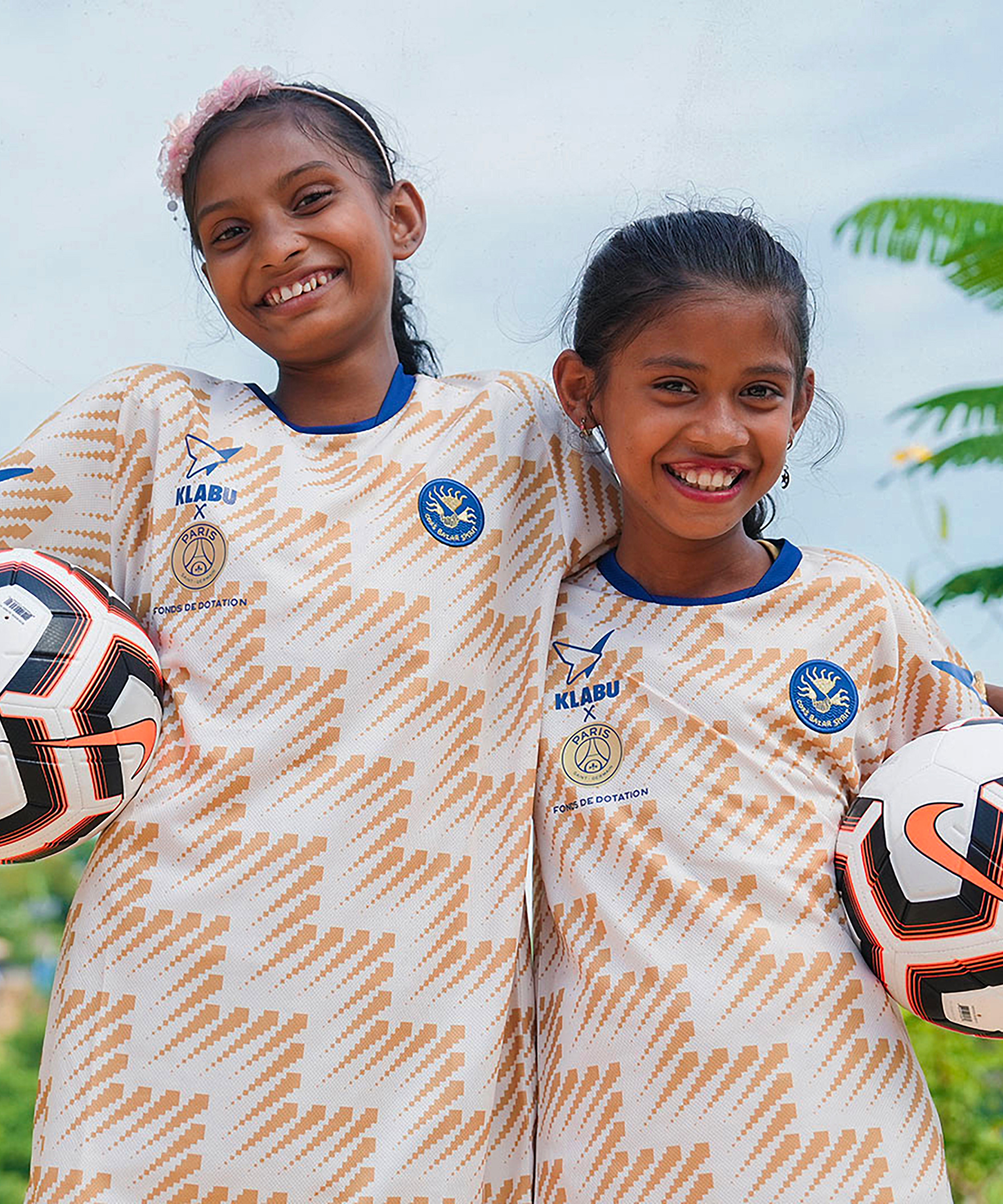 Two girls wearing the KLABU X PSG sportswear shirts