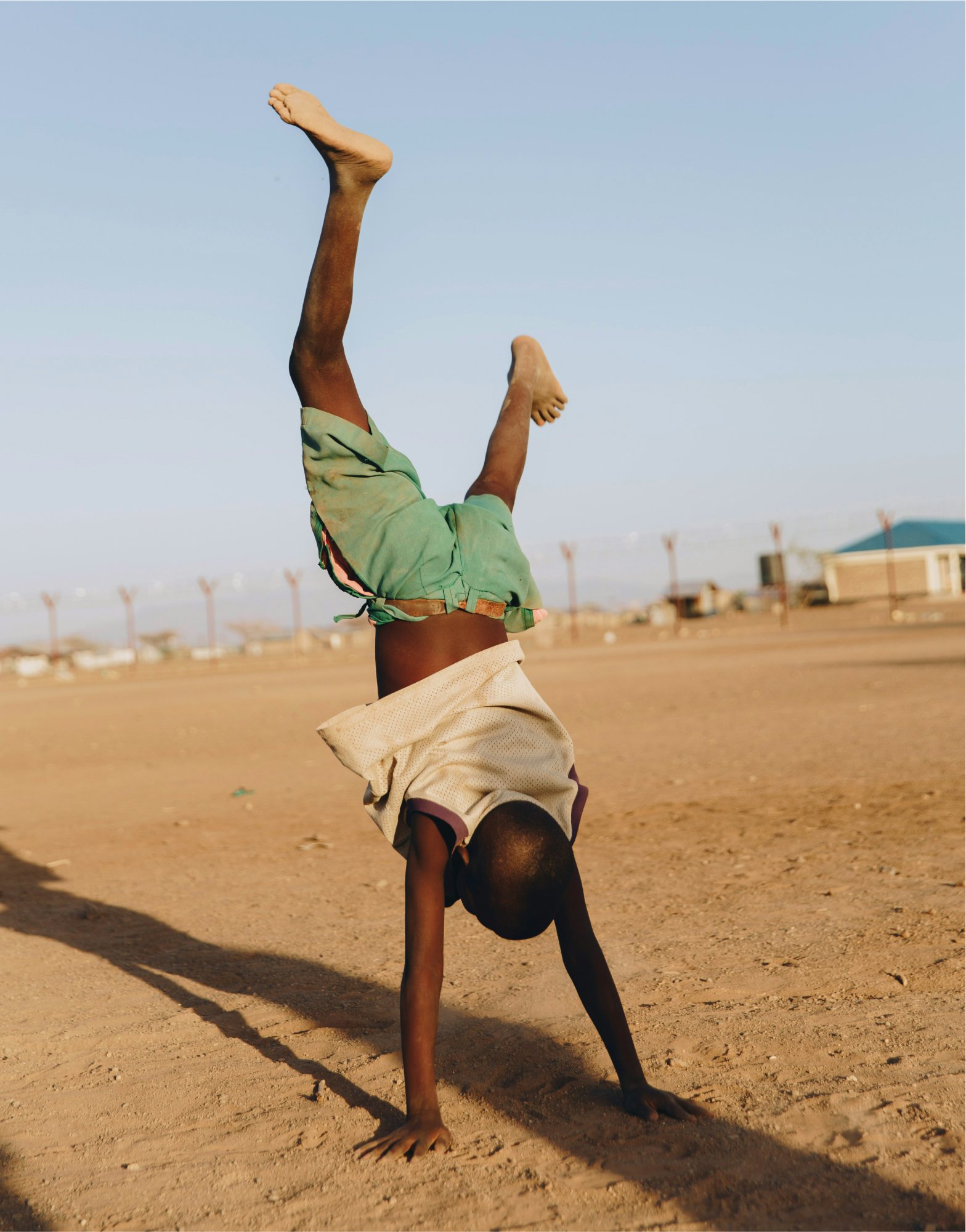 Boy cartwheeling in Kalobbeyei, Kenya