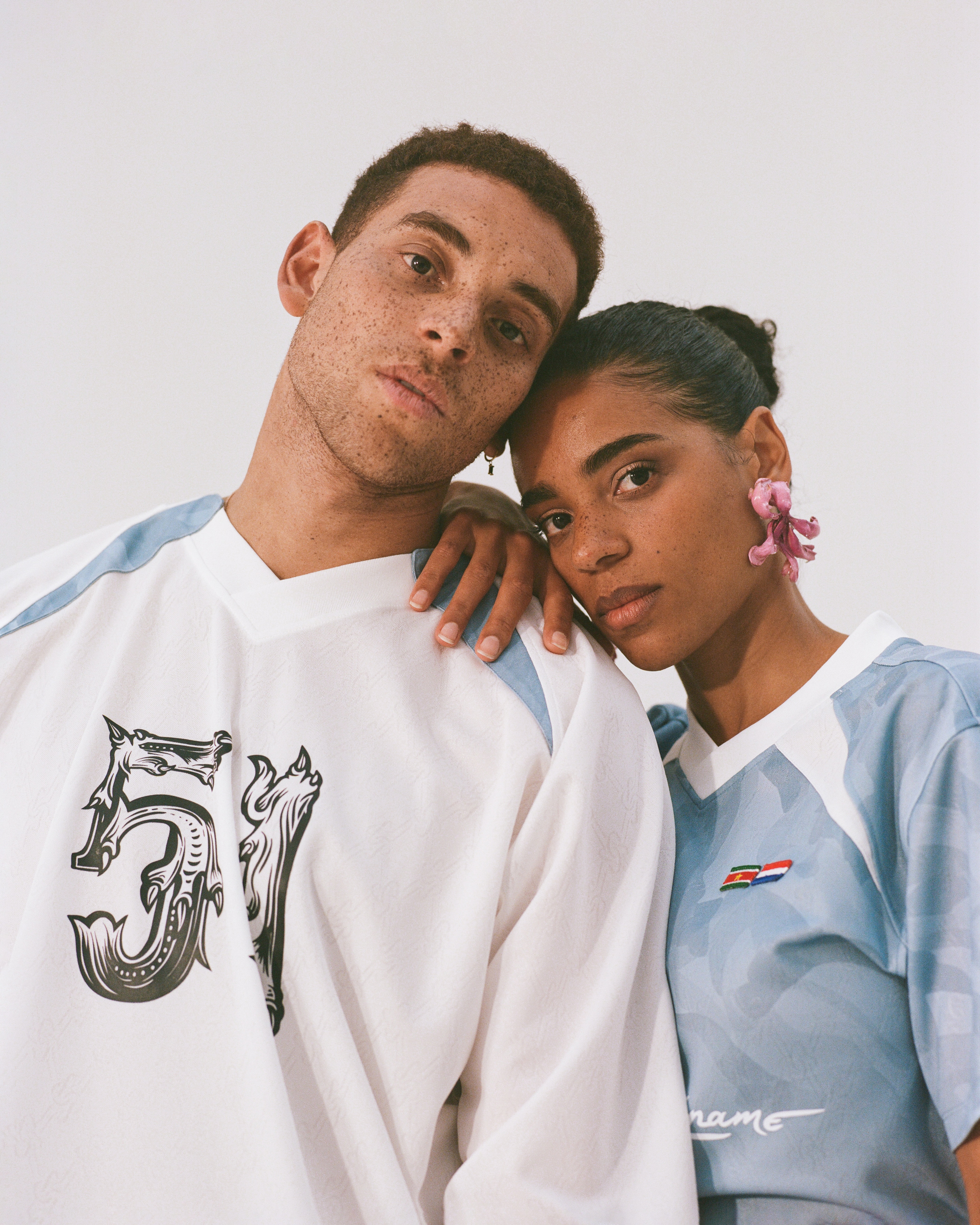 A male and female of surinamese descent posing together wearing limited edition Keti Koti jerseys